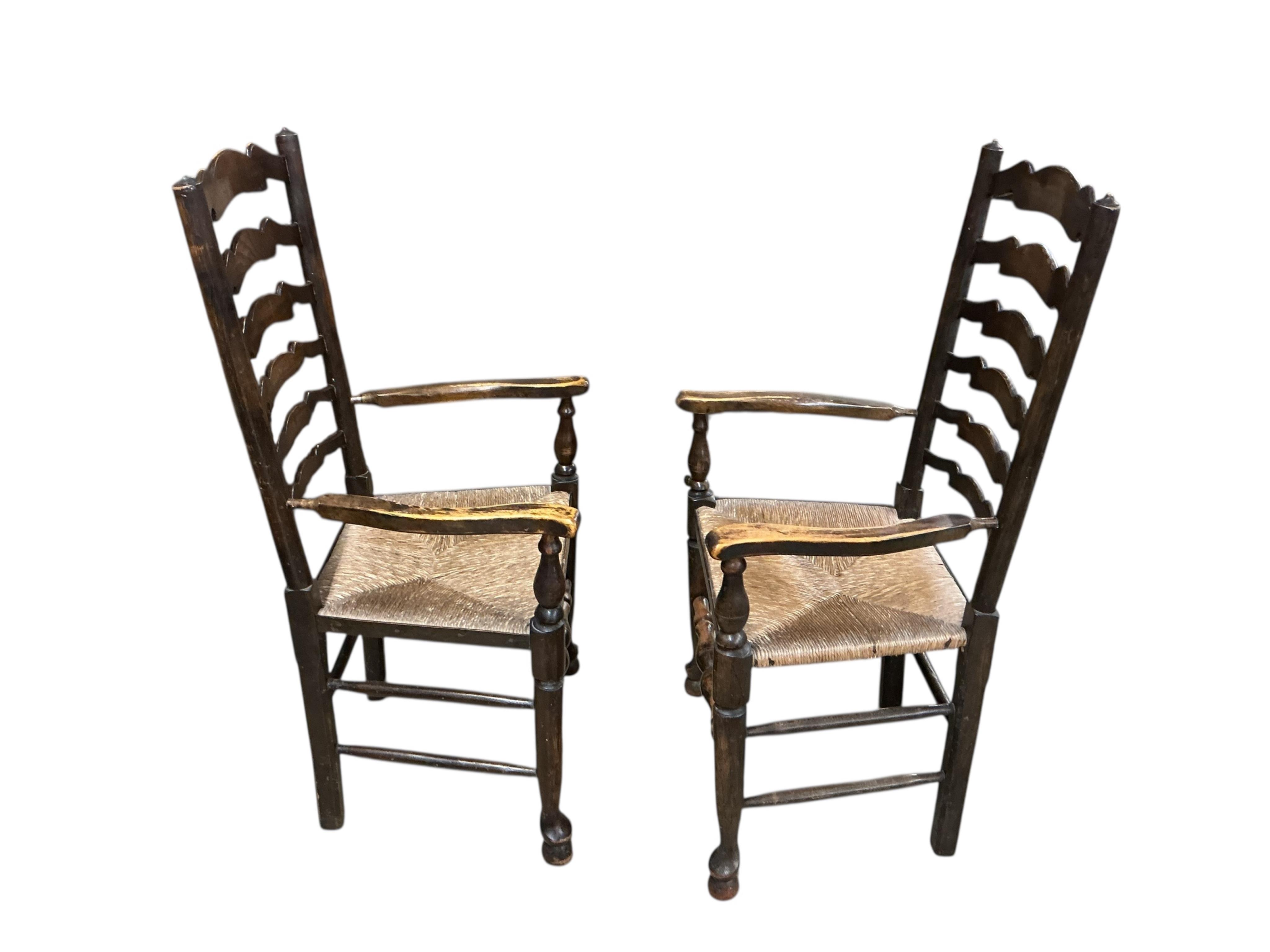 A set of six Lancashire style elm and beech rush seat ladderback dining chairs, two with arms